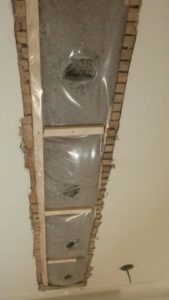 Injection de cellulose dans le plafond d'un logement, via une tranchée.